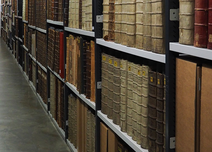 Afbeelding van een boekendepot met daaronder de button naar de pagina's met extra informatie bij digitale collectiestukken